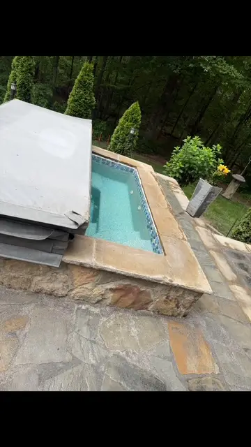 Backyard patio with hot tub at dusk