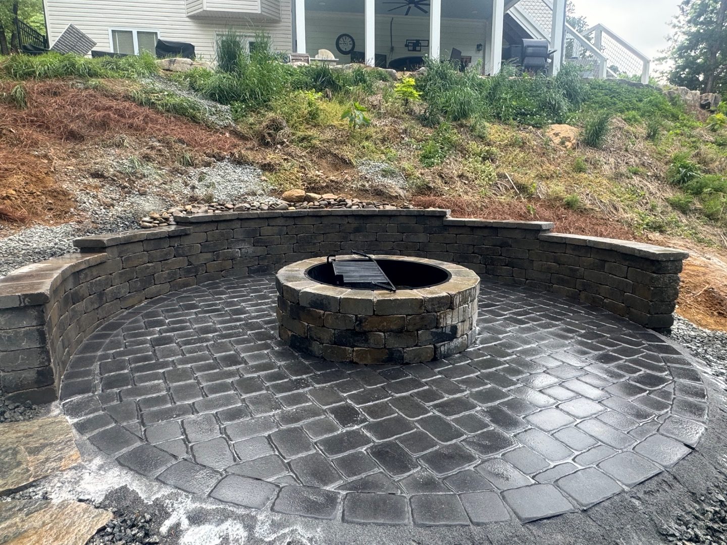 Curved paver seating wall and fire pit by Andrew's Landscaping