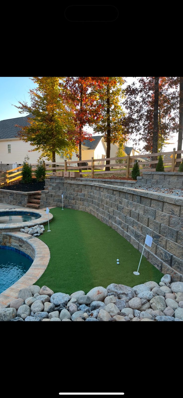 Poolside retaining wall and putting green installation