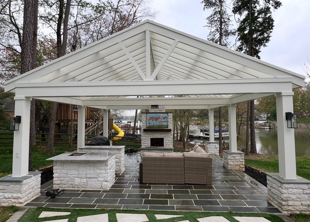 Custom white pavilion with outdoor kitchen and fireplace